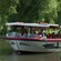 Guests enjoying a boat tour on a tree lined river